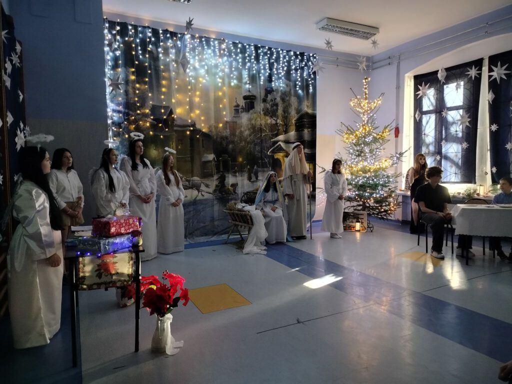 Maryja siedzi przy żłóbku obok niej stoi Józef. 