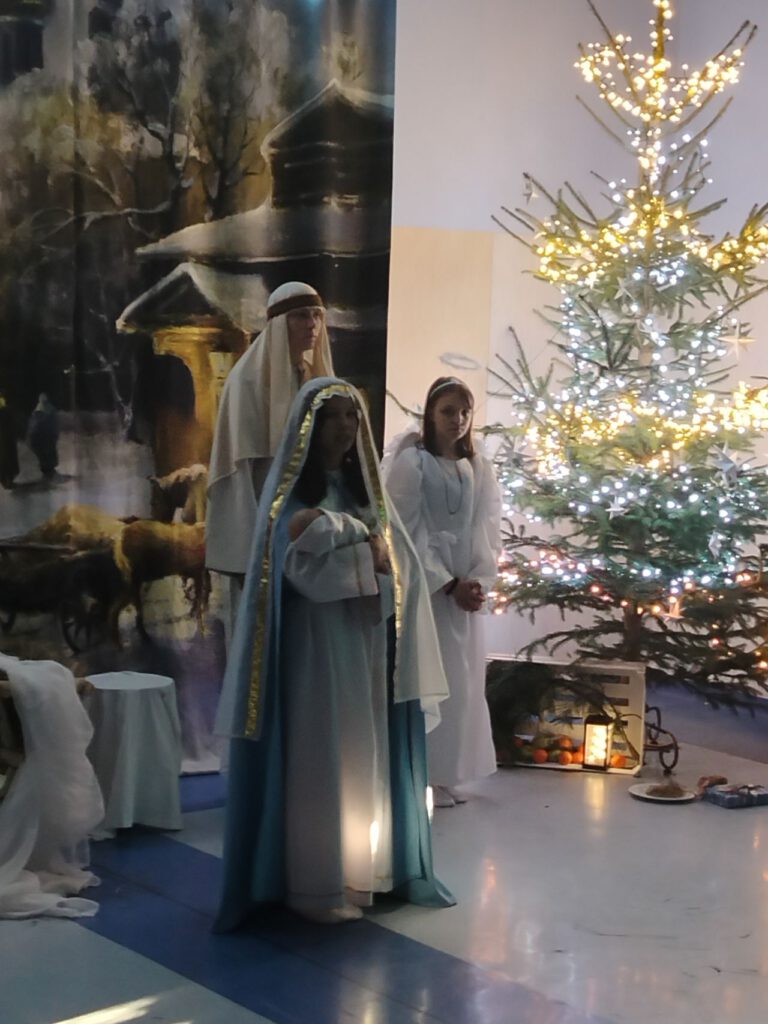 Na środku sali stoi Maryja trzymająca małego Jezuska.