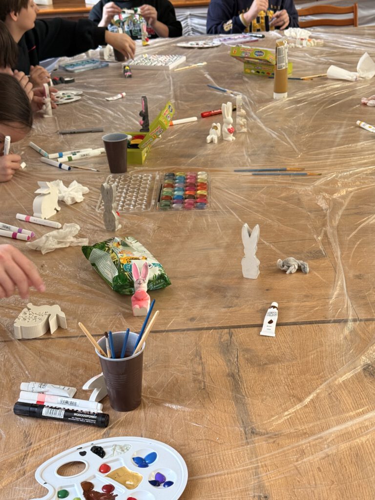 Uczniowie ozdabiają gipsowe figurki zajączków.