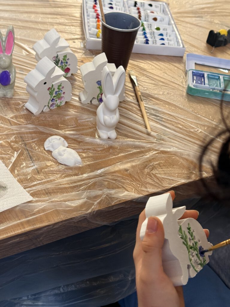 Uczniowie ozdabiają gipsowe figurki zajączków.