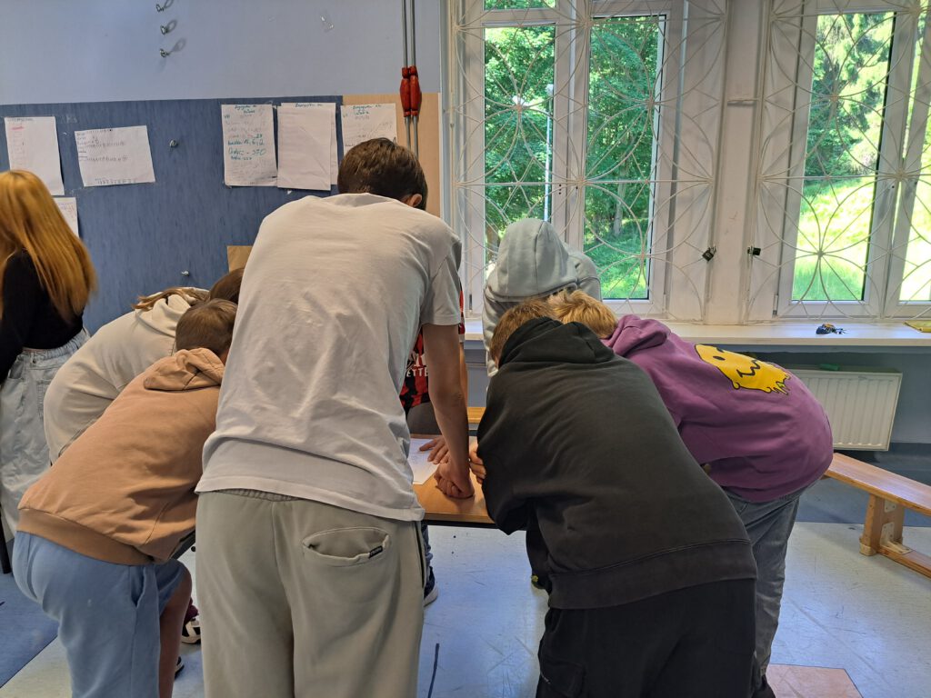 Uczniowie rozwiązują jedne z zadań: wykreślanka wyrazowa.