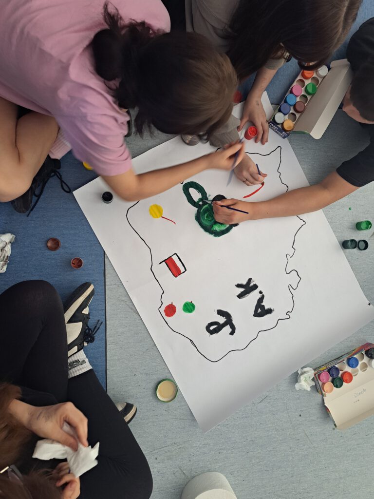 Uczniowie malują plakat "Polska moja ojczyzna"