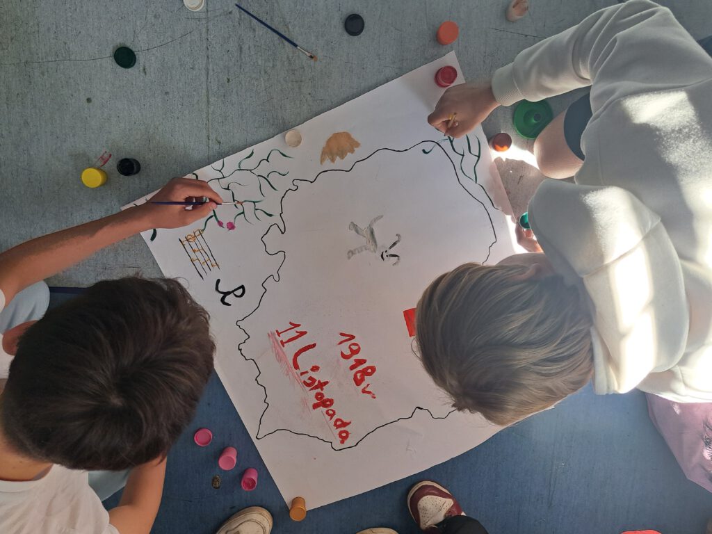 Uczniowie malują plakat "Polska moja ojczyzna"