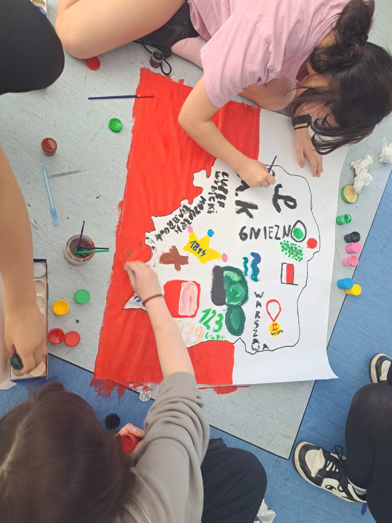 Uczniowie malują plakat "Polska moja ojczyzna"